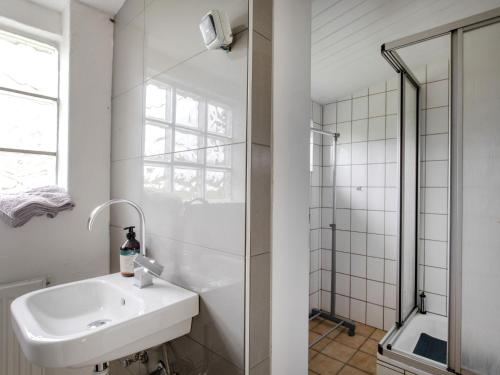 a white bathroom with a sink and a shower at Apartment Zum Kreidesee Hemmoor-2 by Interhome in Oberndorf