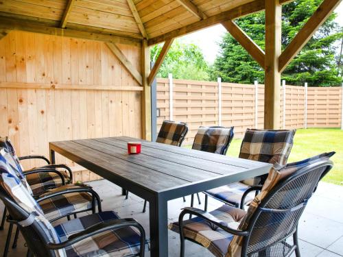 a wooden table with chairs and a red cup on it at Apartment Zum Kreidesee Hemmoor-2 by Interhome in Oberndorf