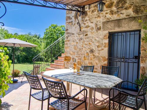 a table and chairs on the patio of a house at Holiday Home La maison aux volets bleus by Interhome in Entrecasteaux