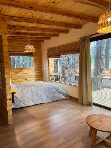 a bedroom with a bed and a large window at La Venecia Cabañas in San Rafael