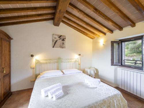 a bedroom with a bed with white sheets and a window at Holiday Home La Dama by Interhome in Poggioni