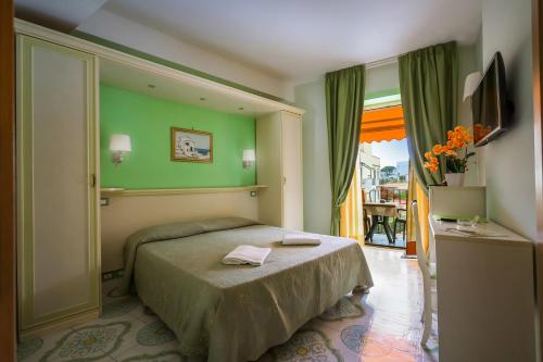a bedroom with a bed with a green wall at Hotel Rivamare in Ischia