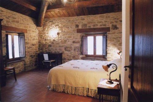 a bedroom with a large bed in a stone wall at Agriturismo Il Casalone in Badia Tedalda