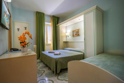 a room with two beds and a mirror at Hotel Rivamare in Ischia