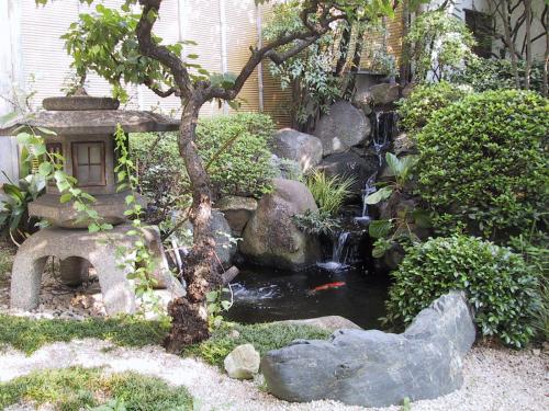 a garden with a waterfall and a koi pond at Ryokan Matsushima in Yokohama