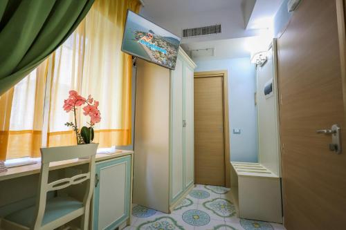 a room with a desk and a window and a television at Hotel Rivamare in Ischia