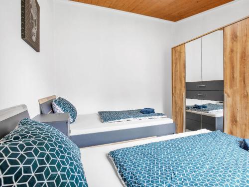 a bedroom with two beds and a mirror at Apartment Zum Kreidesee Hemmoor-1 by Interhome in Oberndorf