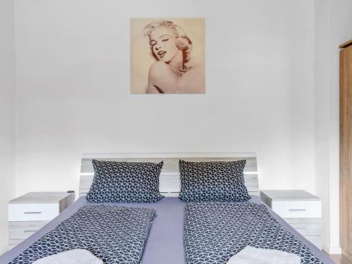 a bedroom with a bed with a picture on the wall at Apartment Zum Kreidesee Hemmoor-1 by Interhome in Oberndorf