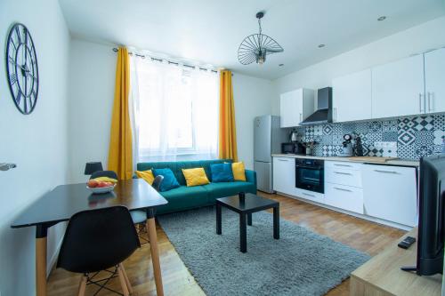 un salon avec un canapé vert et une cuisine dans l'établissement Le Cœur Brestois I hypercentre & 5 min de la gare, à Brest