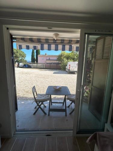 - une table et des chaises sur une terrasse couverte avec une table et une vue dans l'établissement Studio thalie, à Bormes-les-Mimosas
