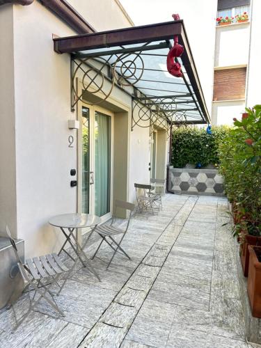 a patio with chairs and tables and awning at Hotel Al Campanile - Luxury Suites & Apartments in Baveno