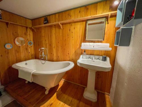 a bathroom with a tub and a sink at La Maison Bleue - Historic House in the Heart of Riquewihr in Riquewihr