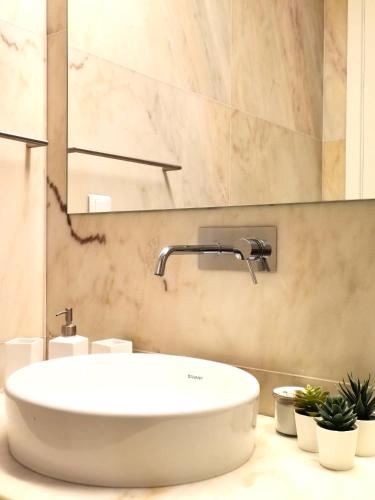 a bathroom with a white sink and a mirror at Casa de Mosqueirões in Santa Margarida da Serra