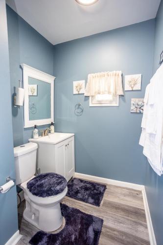 a bathroom with a toilet and a blue wall at Cozy Haven at the footsteps of Harbor East in Baltimore