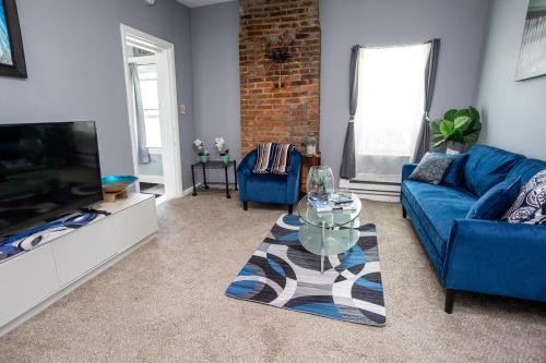 a living room with a blue couch and a tv at Cozy Haven at the footsteps of Harbor East in Baltimore