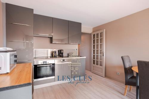 une cuisine avec des appareils en acier inoxydable et une table dans l'établissement Greenwich, à Le Touquet-Paris-Plage