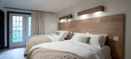 a bedroom with two beds with white comforters at Le Relais des Hautes Gorges in Saint Aime Des Lacs