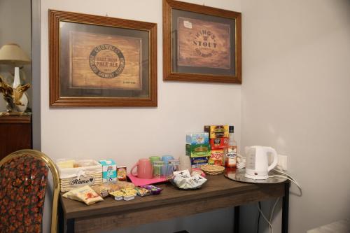 a table with food on it with two pictures on the wall at B&B Royal Palace of Napoli & Reggia di Caserta in Caserta
