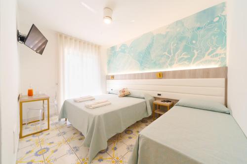 a bedroom with two beds and a painting on the wall at Villa Maredona in Ascea