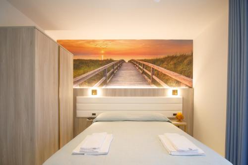 a bed in a room with a painting of a pier at Villa Maredona in Ascea