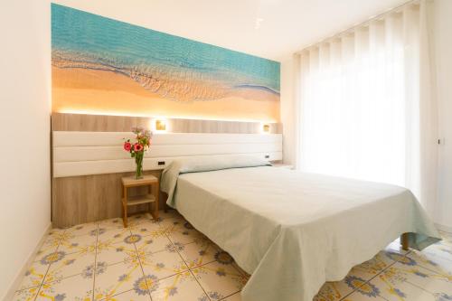 a bedroom with a bed with a painting on the wall at Villa Maredona in Ascea