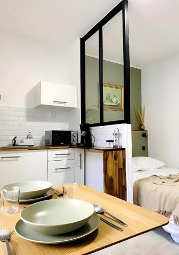 une cuisine avec deux assiettes sur une table en bois dans l'établissement Studio mosaïque Narbonne, à Narbonne