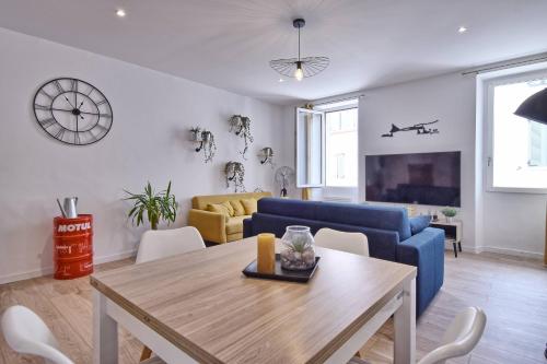 un salon avec une table et un canapé bleu dans l'établissement Joli T2 au Vieux-port - 1er étage, à La Ciotat