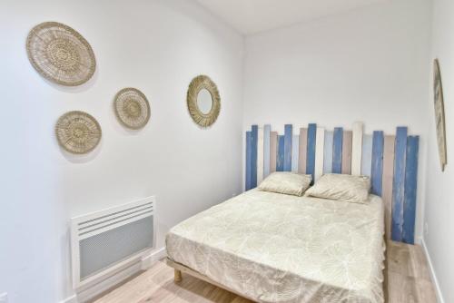 une chambre avec un lit et deux miroirs au mur dans l'établissement Joli T2 au Vieux-port - 1er étage, à La Ciotat