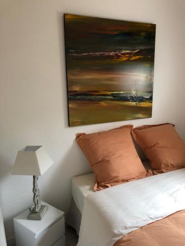 une chambre avec un lit et un tableau au mur dans l'établissement Bel Appartement, à La Croix-Valmer