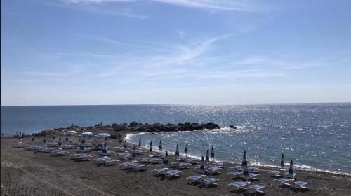 a group of chairs and umbrellas on a beach at Il Sogno di Calipso in Amendolara