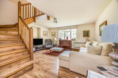 a living room with a couch and a staircase at Charming Annexe Lodge with Parking Pass The Keys in Midhurst