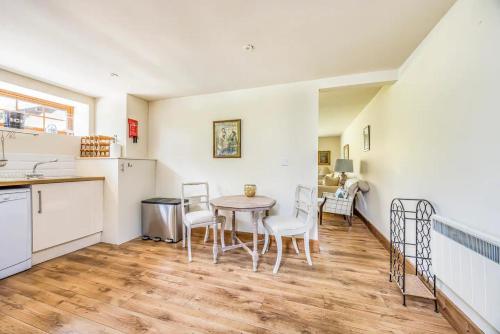 a kitchen and dining room with a table and chairs at Charming Annexe Lodge with Parking Pass The Keys in Midhurst