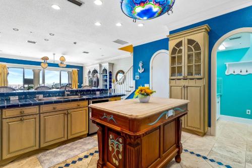 cocina grande con paredes azules y armarios de madera en Ocean Dream Villa, en Clearwater Beach