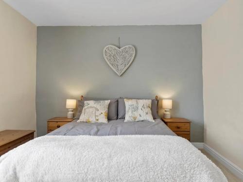 a bedroom with a bed with a heart on the wall at Pass the Keys Newly Renovated 2 Bed Property. in Cleator Moor