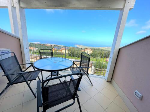 a patio with a table and chairs on a balcony at Affittimoderni Isola Rossa Elite-PATI24 in Cascabraga