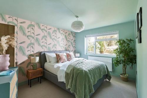 a bedroom with a bed with pink and green walls at Pass the Keys Coastal Boutique Luxury Home With Sea Views in Amlwch