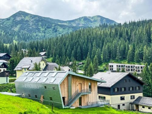 a group of buildings with mountains in the background at Apartment Hideaway Planneralm by Jufa Hotels-3 by Interhome in Donnersbach