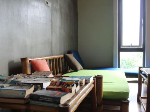 a room with a bed and a table with books at Mad Monkey Hoi An in Hoi An