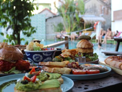 a table topped with plates of food with sandwiches and vegetables at Mad Monkey Hoi An in Hoi An