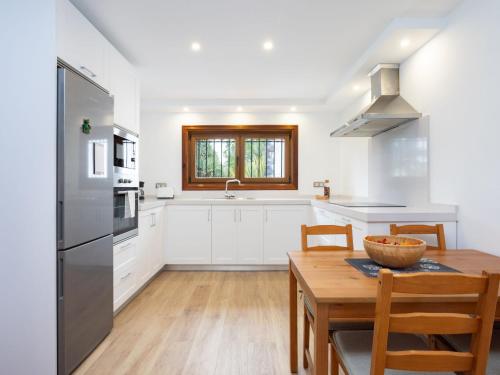 a kitchen with white cabinets and a wooden table at Holiday Home Borges Fuente by Interhome in La Orotava