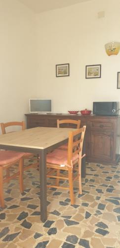 mesa y sillas en una habitación con escritorio en Casa Alice vicino al mare, en Porto Pino