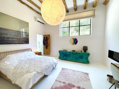 ein Schlafzimmer mit einem Bett und einem großen Fenster in der Unterkunft Stylish 5 bedroom luxury villa with pool and sauna in Santa Eulària des Riu