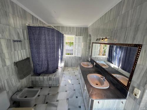 a bathroom with two sinks and a mirror at CASA RURAL A PIE DE PLAYA Remodelada 2024 in Chipiona