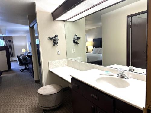a bathroom with a sink and a large mirror at Sojourn Suites Portland Airport in Portland