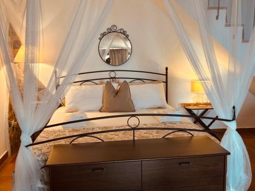 ein Schlafzimmer mit einem Himmelbett und einem Spiegel in der Unterkunft Perla Del Borgo Appartamenti in Santa Caterina dello Ionio