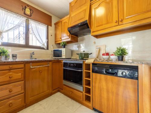 a kitchen with wooden cabinets and a dishwasher at Holiday Home Reca by Interhome in L'Ampolla