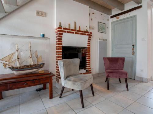 - un salon avec une table et un bateau sur le mur dans l'établissement Holiday Home La Maison du Pêcheur by Interhome, à Pornic