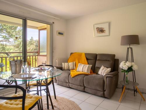 un salon avec un canapé et une table en verre dans l'établissement Apartment Les Terrasses du Golf by Interhome, à Pornic