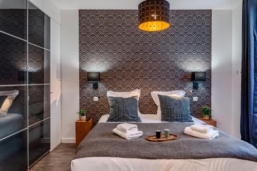 een slaapkamer met een bed met handdoeken erop bij Luxury Family 2BR - Prime Location, Walk to Beach & Shopping, Sunny Balcony - By Totolulu Cannes Hoche in Cannes