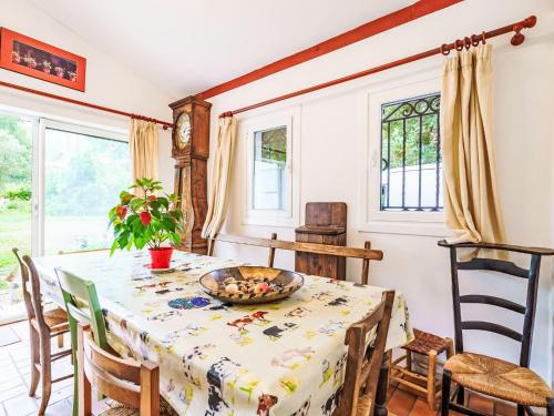 une salle à manger avec une table, des chaises et des fenêtres dans l'établissement Holiday Home Chemin des Carrières by Interhome, à Ascain